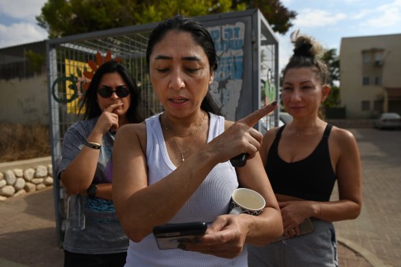 Local residents watch videos of Hamas fighters attacking their town of Ofakim, Israel.