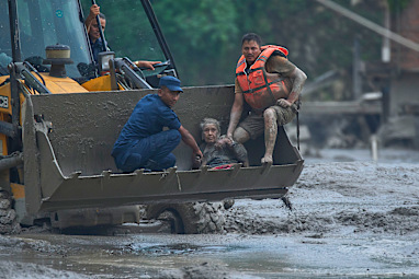 Rescuers in Nuwakot use an earthmover to carry a survivor.