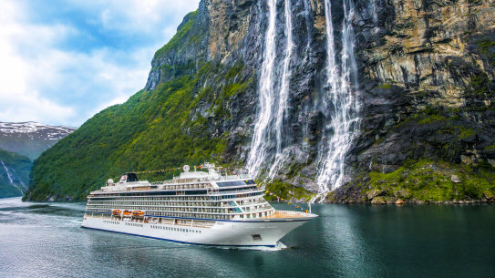 Viking Sky in front of the Seven Sisters Waterfall in Geiranger Fjord, Norway.