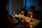 A family eats by candlelight during the blackout in Barcelona.