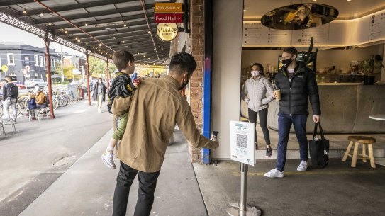 A man uses the QR code at the South Melbourne Market.