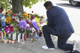 A man reads scripture at the site of a memorial honoring the victims of Saturday’s shooting 