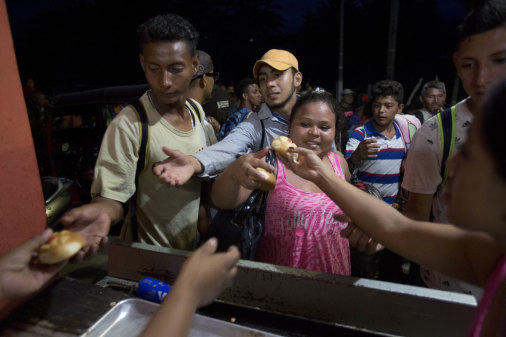 Migrants receive bread from residents in Esquipulas, Guatemala as they make their way to Mexico and the US.