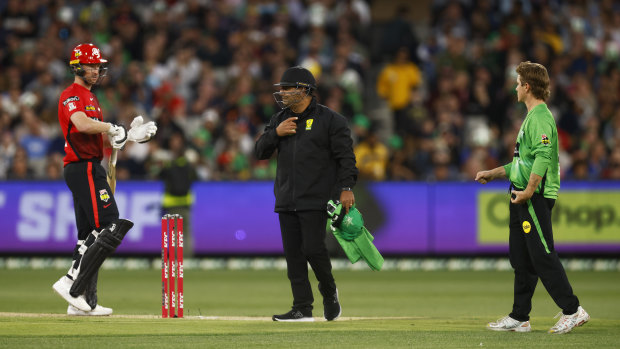 Umpire Gerard Abood with the Renegades’ Tom Rogers (left) and the Stars’ Adam Zampa on Tuesday night.