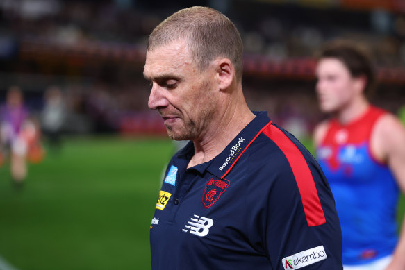 Demons coach Simon Goodwin leaves the field after his side coughed up a four-goal lead to lose to the Lions.