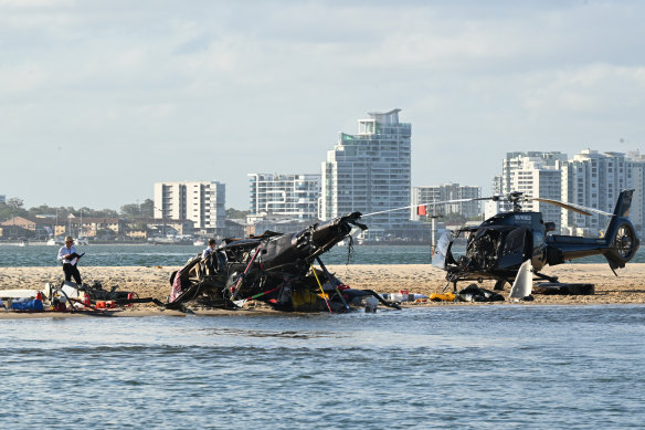 Police inspect a helicopter at the scene of a fatal crash near Sea World on the Gold Coast.