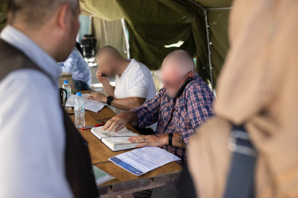 Australian officials work with members of the 1st Battalion, Royal Australian Regiment ready combat team to process evacuees at Hamid Karzai International Airport.