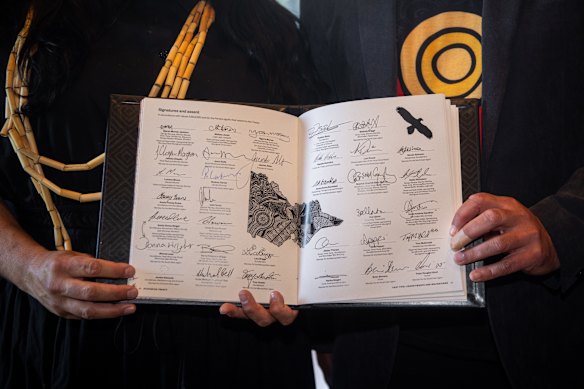 First Peoples’ Assembly co-chairs Ngarra Murray and Rueben Berg hold the signed treaty.