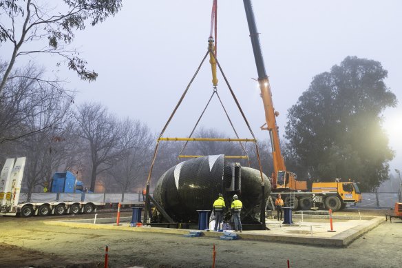 Ouroboros is craned into position, at the front of the National Gallery of Australia on Wednesday morning.