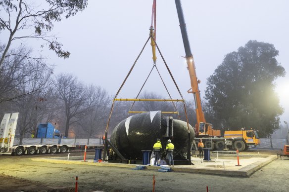 Ouroboros is craned into position, at the front of the National Gallery of Australia on Wednesday morning.