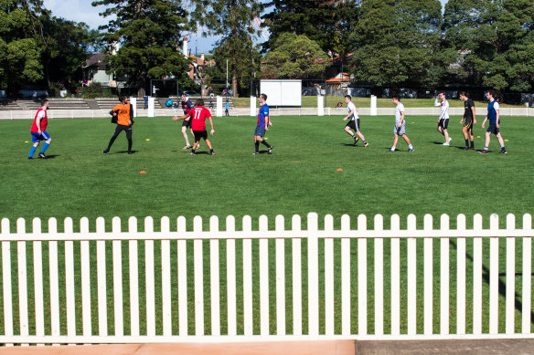 A group of 10 play football at Chatswood Oval on Sunday.