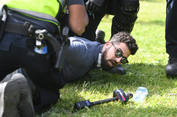 Yemini in 2020, being detained by Victoria Police during an anti-lockdown rally. He later sued them for false arrest and won. 