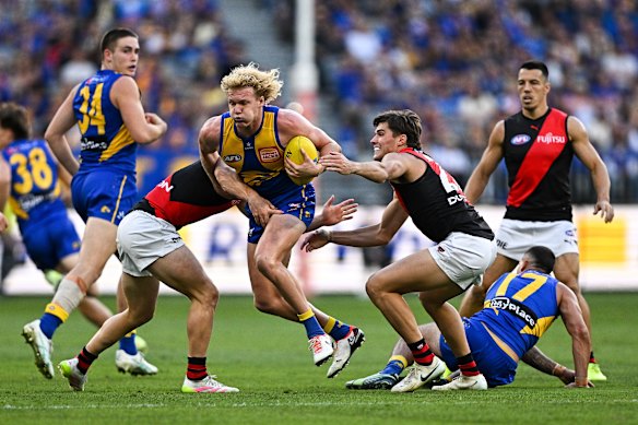 Reuben Ginbey of the Eagles is tackled during the 2025 AFL Round 06 match between the West Coast Eagles and the Essendon Bombers at Optus Stadium.
