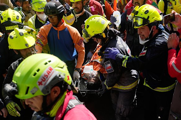 Rescue workers carry Hernán Alberto Gil Flores Gil after being pulled from the rubble eight days after the earthquakes.