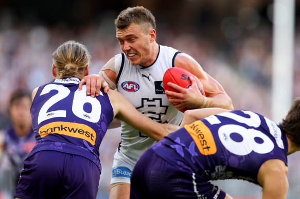 Patrick Cripps fends off two tacklers during the Blues’ win.