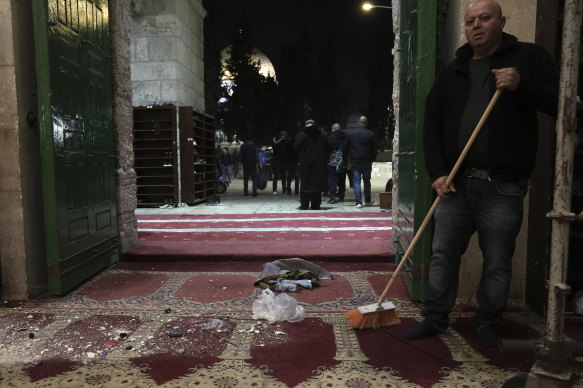A Palestinian worshipper sweeps debris after a raid by Israeli police at the al-Aqsa Mosque compound in the Old City of Jerusalem on Wednesday.