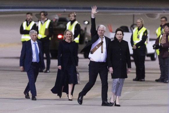 Julian Assange acknowledges supporters waiting for his arrival in Canberra.