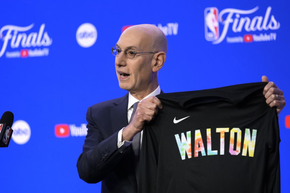 NBA Commissioner Adam Silver displays a warm-up jersey honoring basketball great Bill Walton.