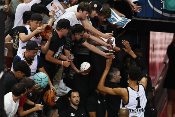 Wembanyama signs autographs for NBA fans.