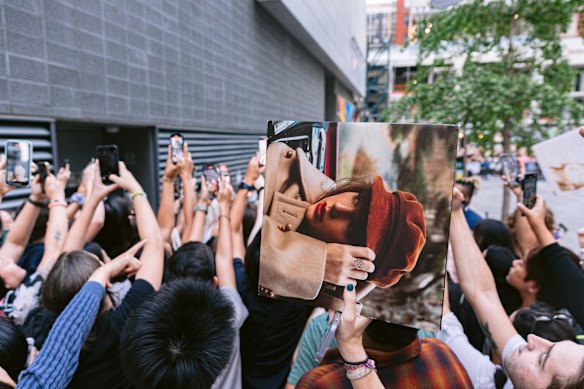 A fan attempts to get their copy of Red: Taylor’s Version signed as Swift greets fans before her conversation at Toronto International Film Festival 2022.