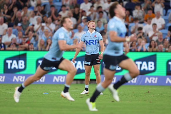 Waratahs players chase a Tane Edmed penalty goal attempt.