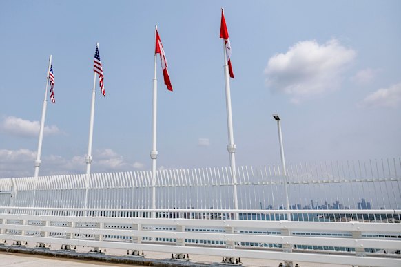 The US and Canadian flags fly on opening day in the middle of the bridge.