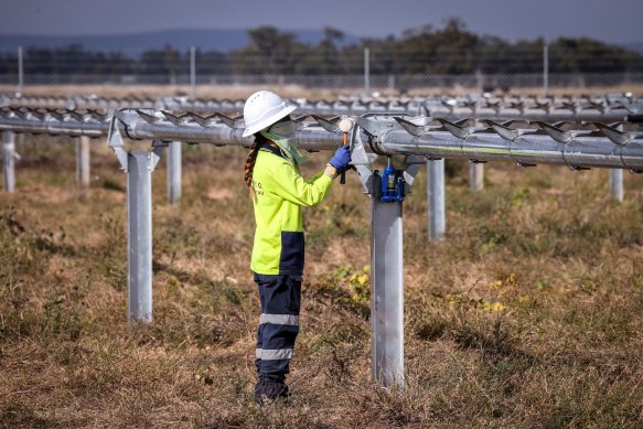 A worker checks newly constructed metal frames for photovoltaic solar farm. The Grattan Institute advocates government intervention in the green economy.