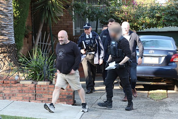 Waste company director Anthony Malcolm (left) during an AFP raid in Melbourne on Tuesday.