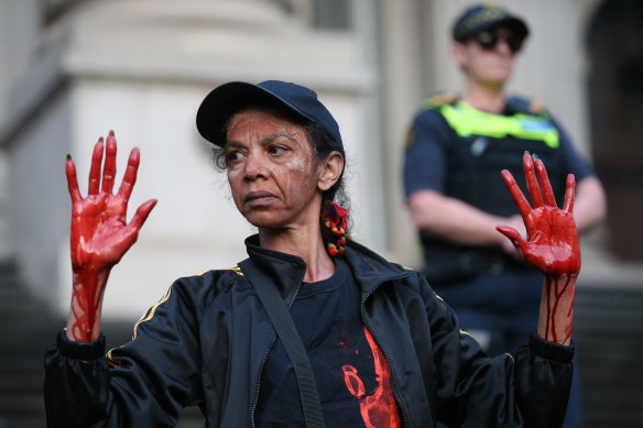 Aboriginal and Torres Strait Islanders communities and allies with their hands painted red march during a protest in Melbourne last year following the death of 19-year-old Warlpiri teenager Kumanjayi Walker.
