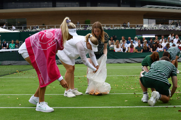 Britain’s Katie Boulter (left) and Australia’s Daria Saville help to pick up confetti thrown by a protester.