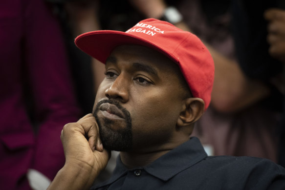 Rapper Kanye West, now known as Ye, listens during a meeting with then-President Donald Trump at the White House in October 2018. 