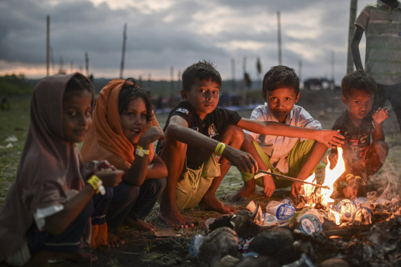 Rohingya children sit around a fire at their camp near a beach in Pidie, Aceh province, Indonesia, in December.