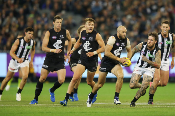 Cripps (centre) and Judd (with ball) in action against the old enemy, Collingwood.