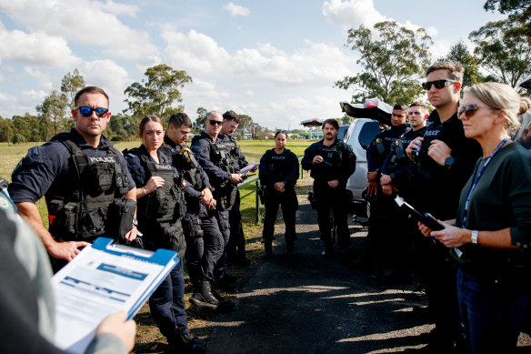 Police gather ahead of an Amarok raid for a briefing.