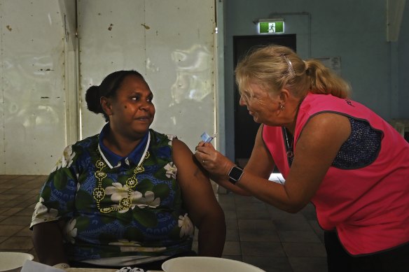 Norah Tabuai receives her second AstraZeneca COVID-19 vaccination on Saibai Island from a Queensland Health nurse.