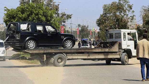 A damaged vehicle is removed from the scene of the blast that occurred as Hamdallah's convoy entered Gaza.