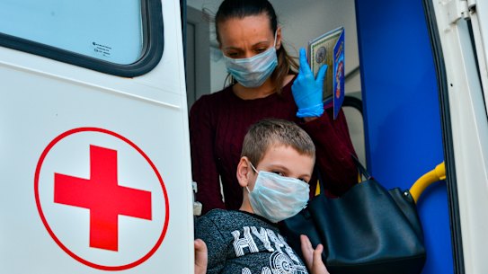 A boy and his mother leave a COVID-19 testing unit in Adygea, Russia.