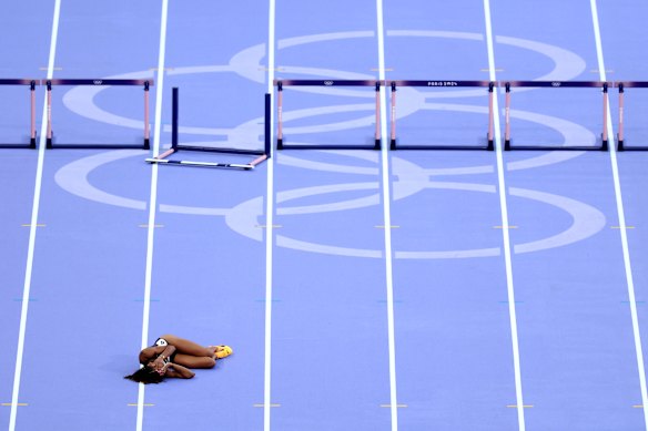 Lina Nielsen, of Britain, lies on the track after falling over a hurdle while competing in the women’s 400 meters hurdles semifinal.