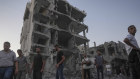 Palestinians stand in rubble after an Israeli airstrike in Deir al Balah on the Gaza Strip on August 6.