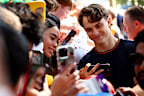 Oscar Piastri poses for a selfie with a fan at the 2026 Australian Grand Prix.