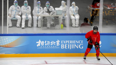 Medical personnel in protective suits watch the China Ice Sports College hockey team practise on Wednesday in  a test event for the 2022 Beijing Winter Olympics.