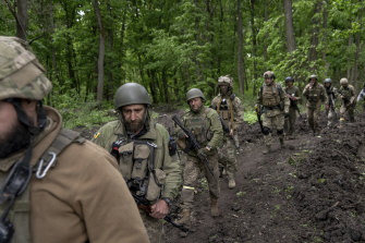 Ukrainian servicemen walk in the forest near a recently retaken village, north of Kharkiv.