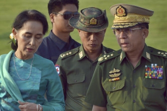Aung San Suu Kyi (left) who has been detained in the coup, walks with General Min Aung Hlaing (right) in 2016.