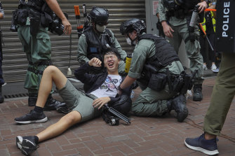 A reporter falls after being sprayed with pepper spray by police during a protest in Causeway Bay in Hong Kong in July. 