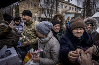 People crowd around a  truck distributing aid in Borodyanka, Ukraine, on Tuesday.