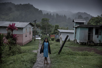 A young woman standing in the rain in the village of Naviavia, which has been bought from Fiji by Kiribati to ensure that Kiribati islanders have a place to go when the sea level overcomes their islands.