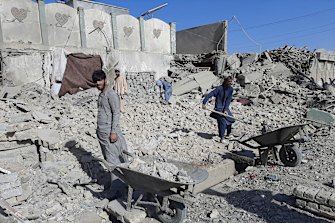 Afghans inspect a damaged building after airstrikes in Lashkar Gah city of Helmand province, south of Kabul, Afghanistan, Sunday, August 8, 2021. 