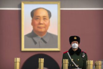 A paramilitary policeman stands guard in front of a giant portrait of the late Chinese leader Mao Zedong in Beijing.