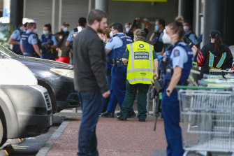 Police and ambulance staff attend the scene outside the Auckland supermarket.
