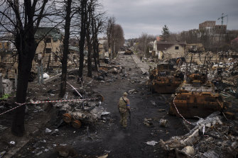 在烏克蘭基輔郊區的布查，一名烏克蘭軍人在被摧毀的俄羅斯坦克中行走。